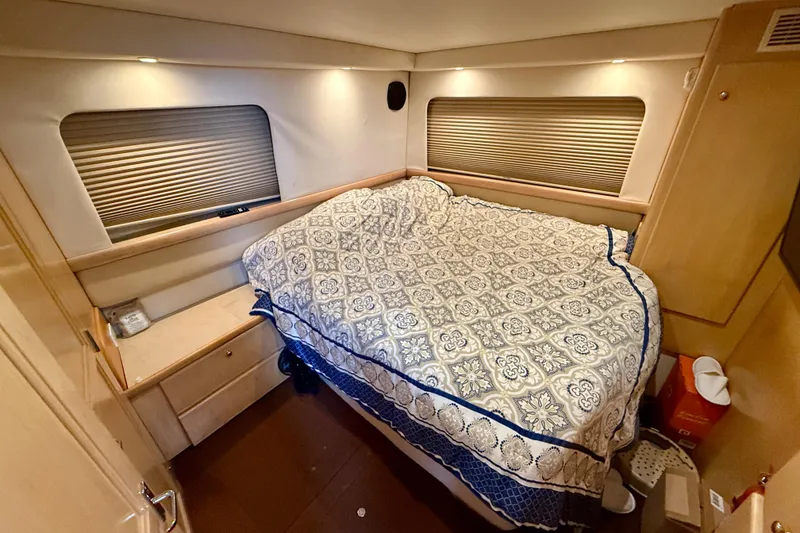 Slide: The Image of 1997 Carver 355 Aft Cabin Motor Yacht bedroom with patterned bedding and wooden cabinetry. - 28