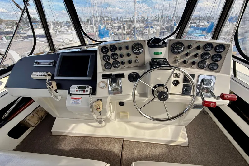 Slide: The Image of 1997 Carver 355 Aft Cabin Motor Yacht helm with steering wheel and control panel. - 13