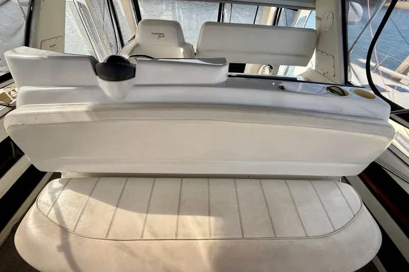 Slide: The Image of 1997 Carver 355 Aft Cabin Motor Yacht interior with white seating and helm view. - 19