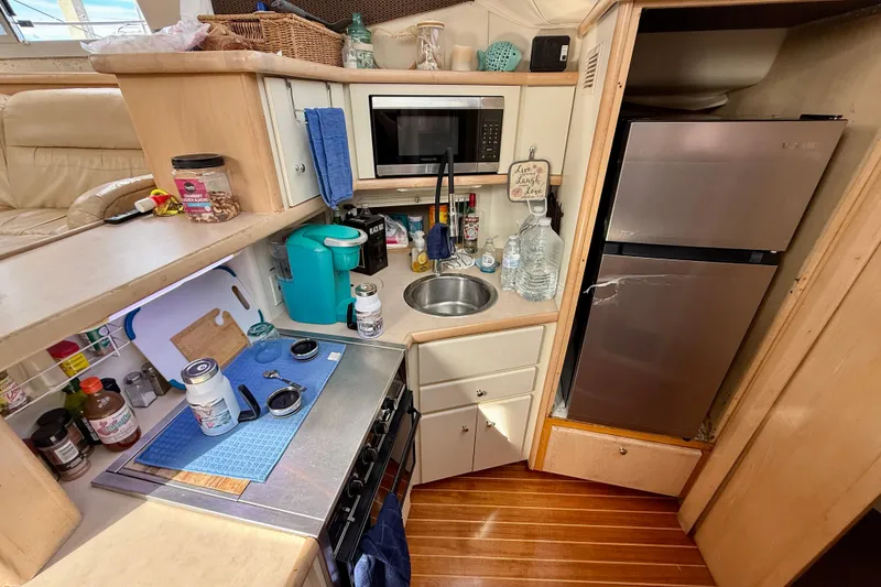 Slide: The Image of 1997 Carver 355 Aft Cabin Motor Yacht kitchen with appliances and wooden flooring. - 24