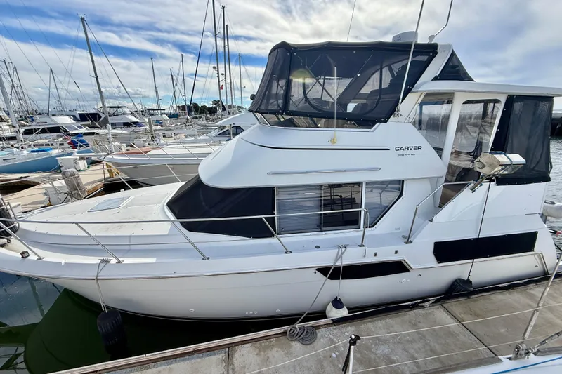 Slide: The Image of 1997 Carver 355 Aft Cabin Motor Yacht docked at marina under blue sky. - 4
