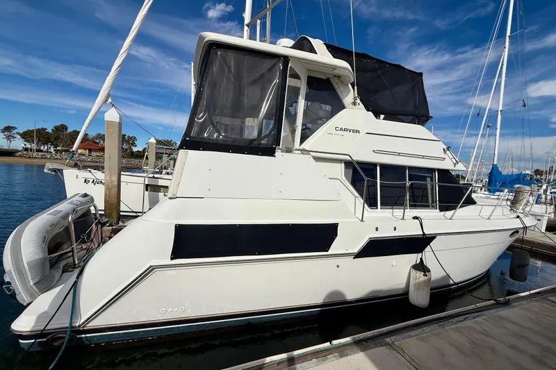 Slide: The Image of 1997 Carver 355 Aft Cabin Motor Yacht docked at marina under clear blue sky. - 7