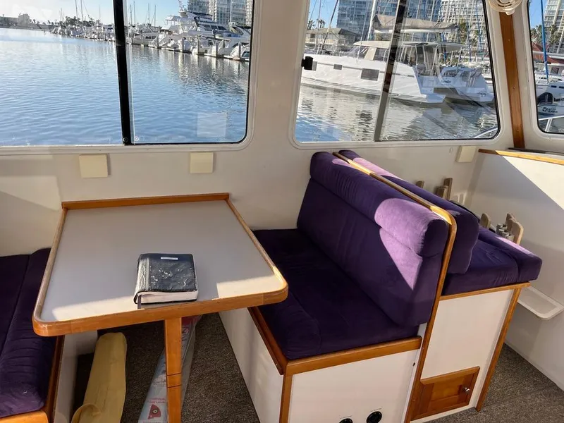 Slide: The Image of Interior of 2001 Northern Bay 36 boat with purple seating and marina view. - 23