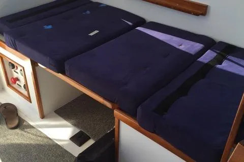 Slide: The Image of Interior cabin seating with blue cushions in a 2001 Northern Bay 36 boat. - 24