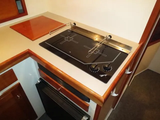 Slide: The Image of 2001 Northern Bay 36 kitchen with modern stovetop and wooden cabinetry. - 26