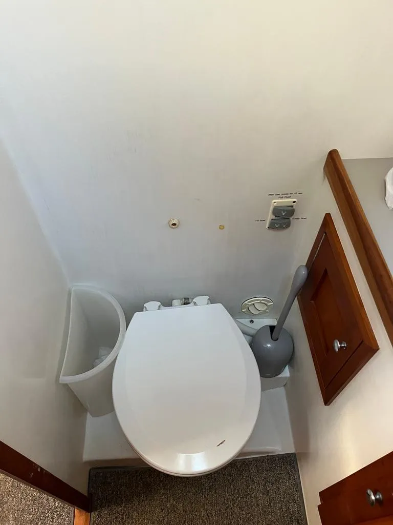 Slide: The Image of Boat bathroom interior with toilet, wooden cabinets, and cleaning supplies on a Northern Bay 36, 2001. - 31