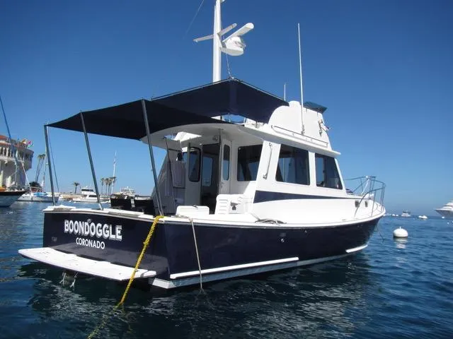 Slide: The Image of 2001 Northern Bay 36 boat anchored in clear blue water, featuring a canopy and sleek design. - 5