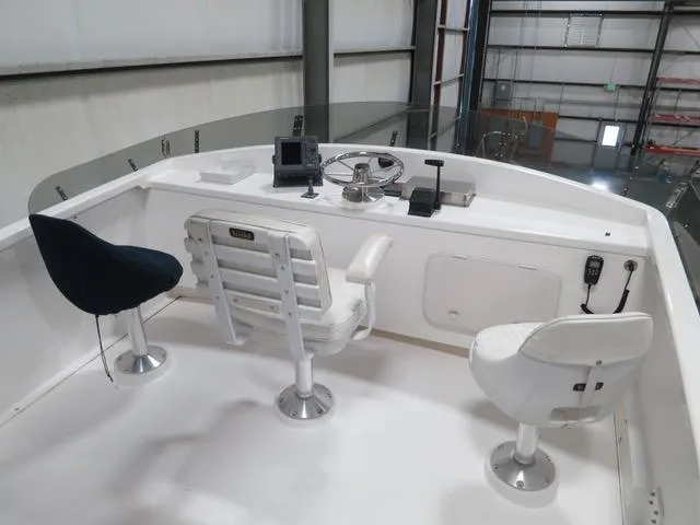 Slide: The Image of 2001 Northern Bay 36 boat helm with three seats and navigation equipment in a storage facility. - 8