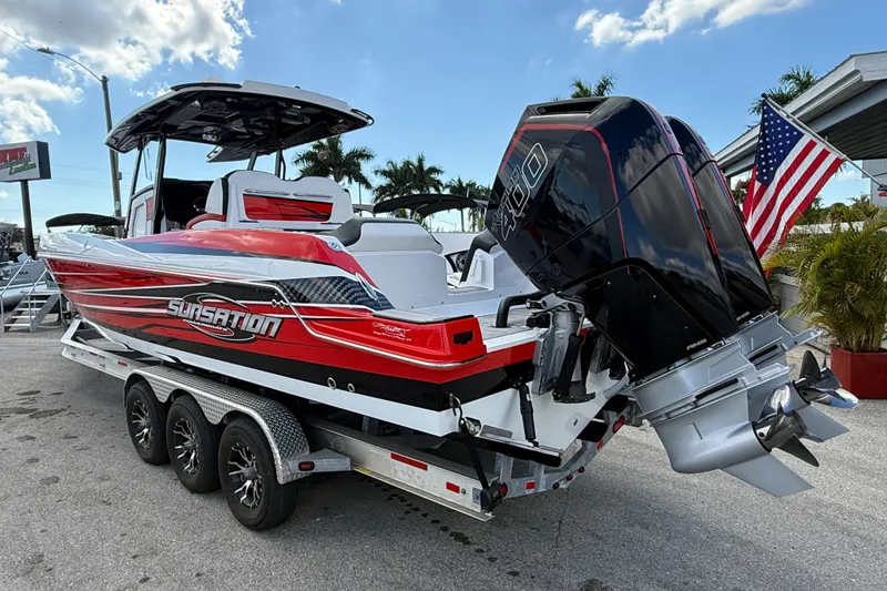 Slide: The Image of 2025 Sunsation 32 CCX boat on trailer with powerful outboard motor, American flag in background. - 10