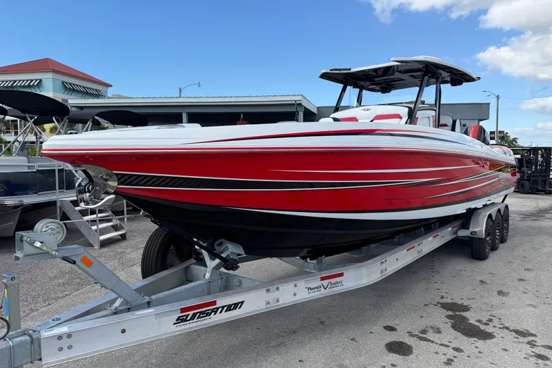 Slide: The Image of 2025 Sunsation 32 CCX boat in vibrant red on a trailer, ready for adventure. - 3