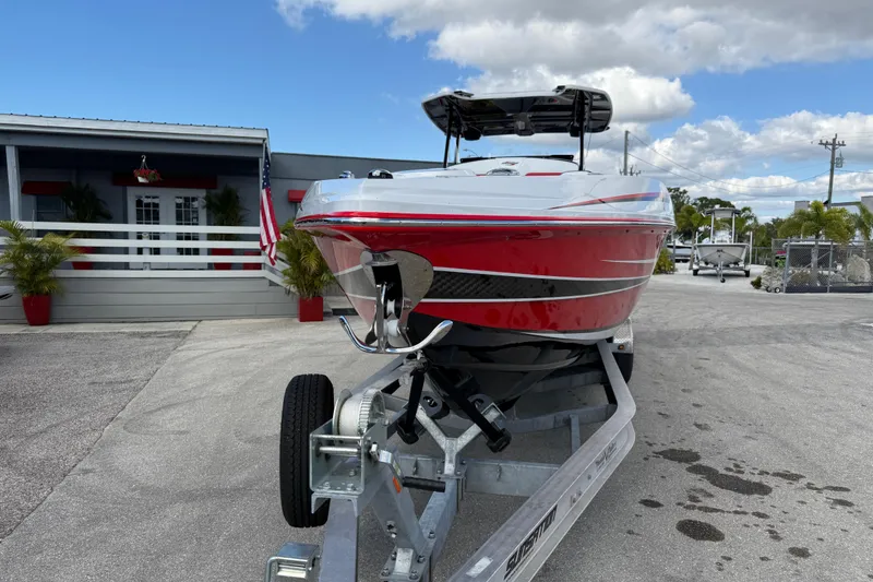 Slide: The Image of 2025 Sunsation 32 CCX boat on trailer, red and white design, parked outdoors. - 4