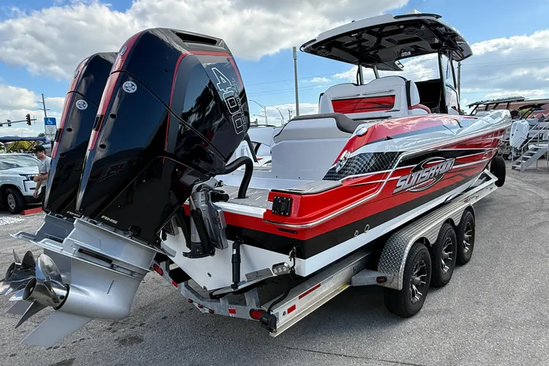 Slide: The Image of 2025 Sunsation 32 CCX powerboat with dual engines on a trailer, under a partly cloudy sky. - 7