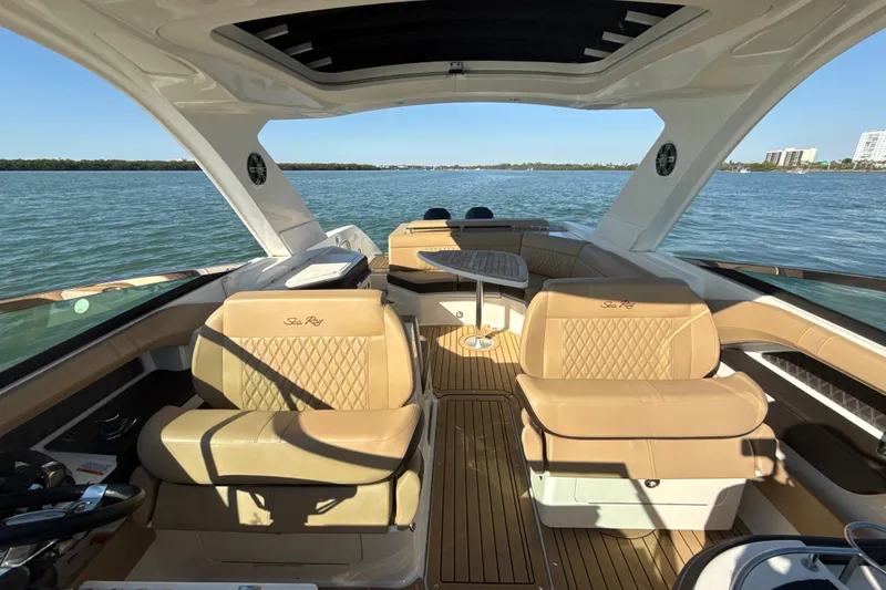 Slide: The Image of 2021 Sea Ray SLX 310 Outboard boat interior with luxurious seating and scenic water view. - 10