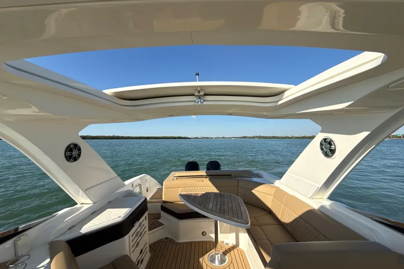 Slide: The Image of Luxurious 2021 Sea Ray SLX 310 Outboard boat interior with open roof and scenic water view. - 11