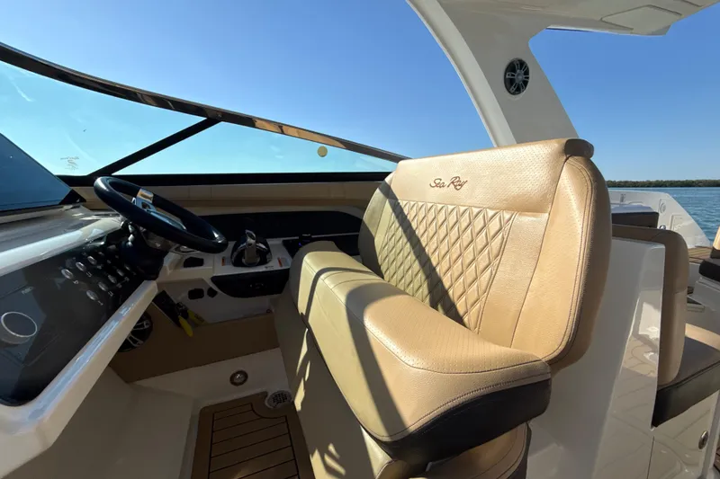Slide: The Image of 2021 Sea Ray SLX 310 Outboard interior with luxurious tan seating and sleek dashboard. - 14