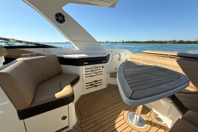 Slide: The Image of Luxurious 2021 Sea Ray SLX 310 Outboard boat interior with elegant seating and table. - 18
