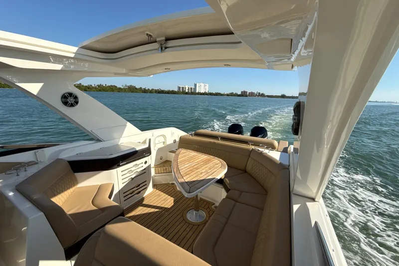 Slide: The Image of 2021 Sea Ray SLX 310 Outboard cruising on open water, featuring luxurious seating and sleek design. - 21