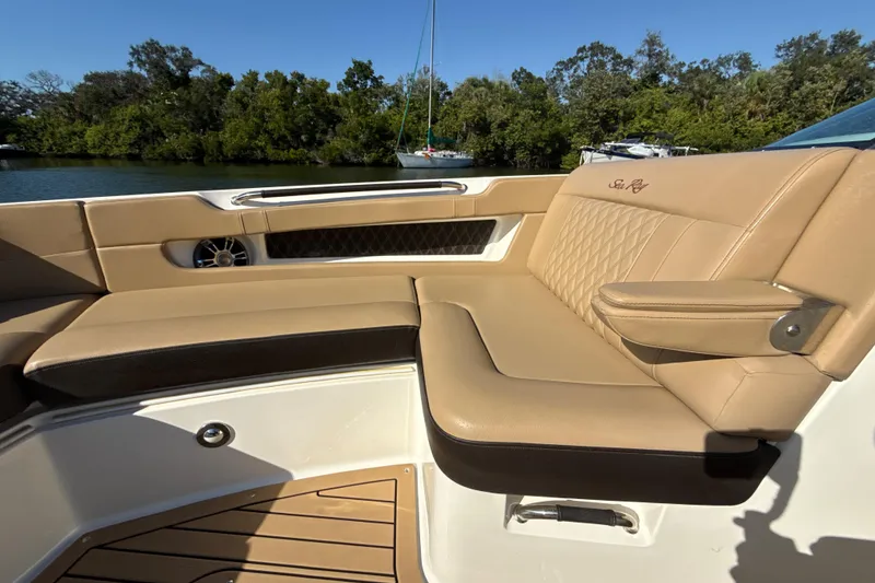 Slide: The Image of Luxurious seating on 2021 Sea Ray SLX 310 Outboard boat, with tan upholstery and scenic water view. - 9