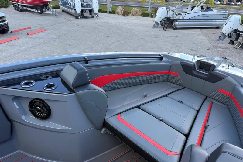 Slide: The Image of 2026 Sunsation 34 CCX boat interior with gray and red seating, cup holders, and speaker. - 14