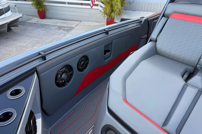 Slide: The Image of 2026 Sunsation 34 CCX boat interior with gray and red seating, speakers, and cup holders. - 18