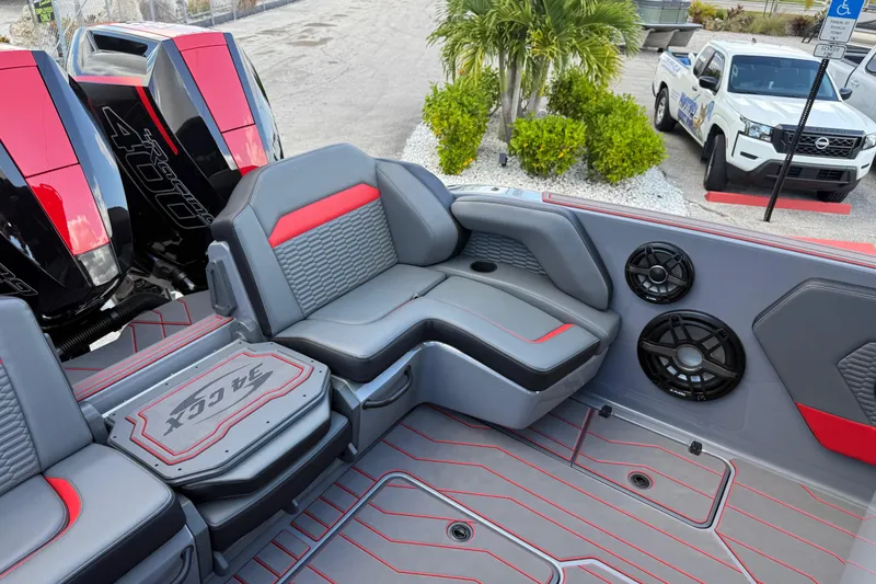 Slide: The Image of 2026 Sunsation 34 CCX boat interior with gray and red seating, speakers, and powerful engines. - 24
