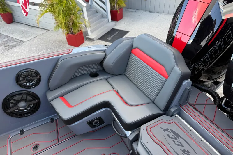 Slide: The Image of 2026 Sunsation 34 CCX boat interior with gray and red seating, speakers, and engine detail. - 26