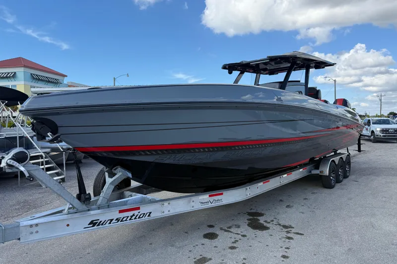 Slide: The Image of 2026 Sunsation 34 CCX boat on trailer, sleek gray design with red accents. - 3