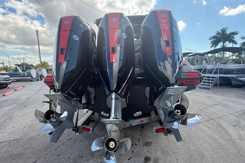 Slide: The Image of 2026 Sunsation 34 CCX boat with triple outboard engines, parked outdoors. - 9