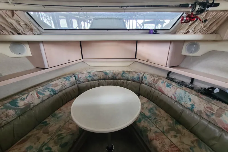 Slide: The Image of 1997 Bayliner 3255 Avanti cabin interior with floral seating and round table. - 11