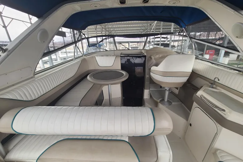 Slide: The Image of 1997 Bayliner 3255 Avanti boat interior with white seating and helm station. - 4