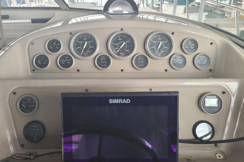 Slide: The Image of Dashboard of a 1997 Bayliner 3255 Avanti boat with gauges and Simrad display. - 8