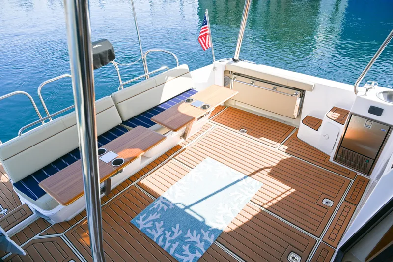 Slide: The Image of 2022 Ranger Tugs R-43 CB boat deck with seating and American flag. - 15