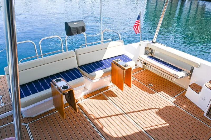 Slide: The Image of 2022 Ranger Tugs R-43 CB boat deck with seating, cup holders, and American flag. - 19