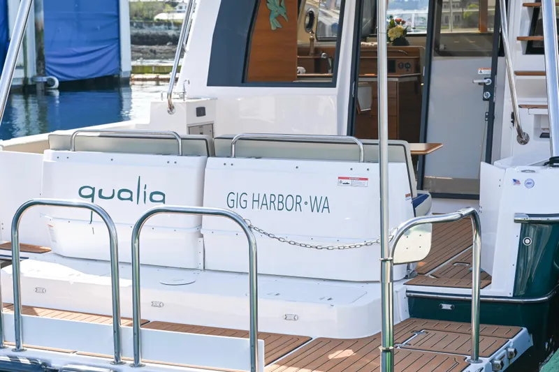 Slide: The Image of 2022 Ranger Tugs R-43 CB boat docked, featuring "Qualia" and "Gig Harbor, WA" on the stern. - 22
