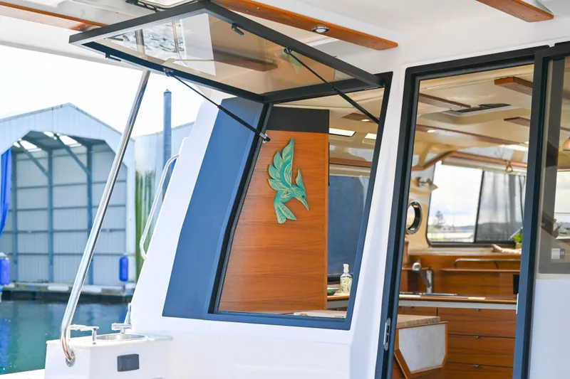 Slide: The Image of 2022 Ranger Tugs R-43 CB yacht interior with open window and wooden accents. - 23