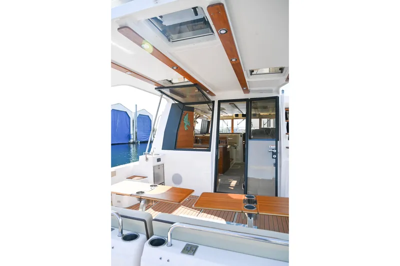 Slide: The Image of 2022 Ranger Tugs R-43 CB yacht interior with wooden accents and open deck view. - 24