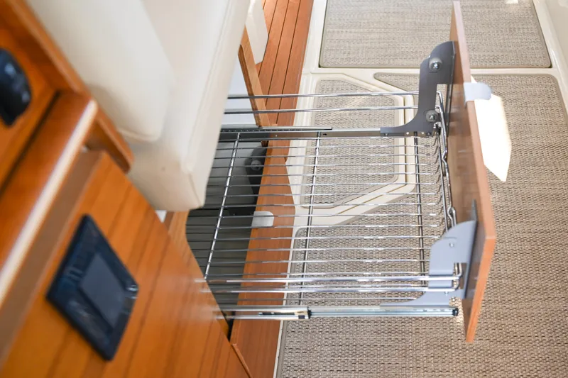 Slide: The Image of 2022 Ranger Tugs R-43 CB interior with open wooden drawer and wire basket. - 33