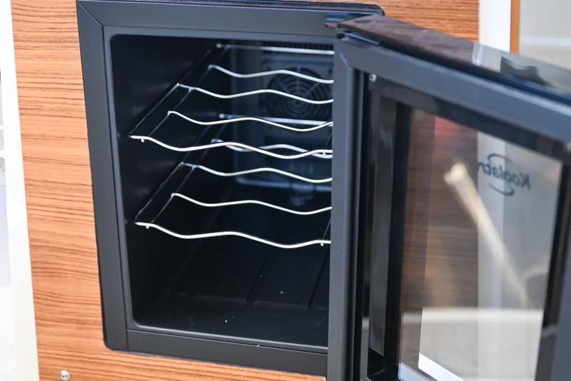 Slide: The Image of Open wine cooler on 2022 Ranger Tugs R-43 CB boat, featuring wooden paneling. - 36