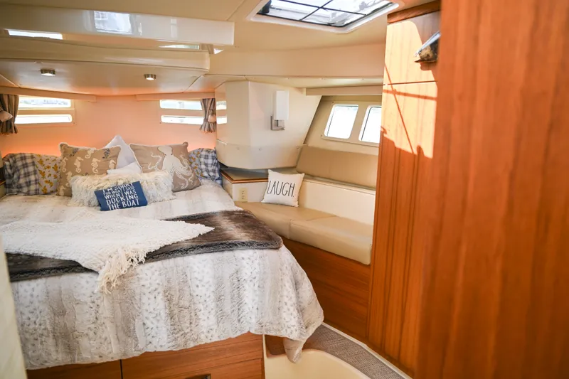 Slide: The Image of Cozy interior of 2022 Ranger Tugs R-43 CB with plush bedding and decorative pillows. - 42