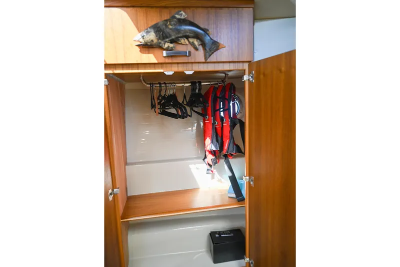 Slide: The Image of 2022 Ranger Tugs R-43 CB closet with life jackets and hangers. - 49