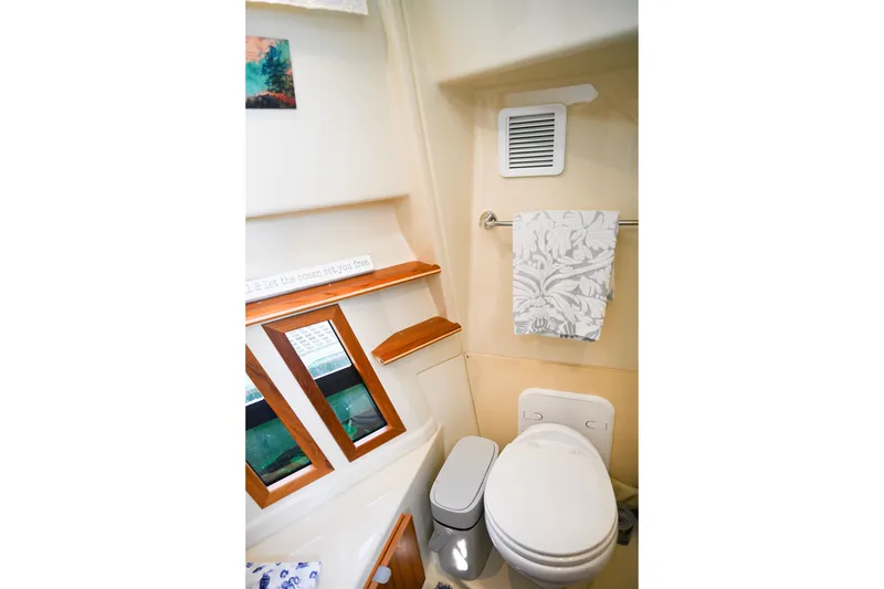 Slide: The Image of 2022 Ranger Tugs R-43 CB bathroom with toilet, towel, and decorative elements. - 55
