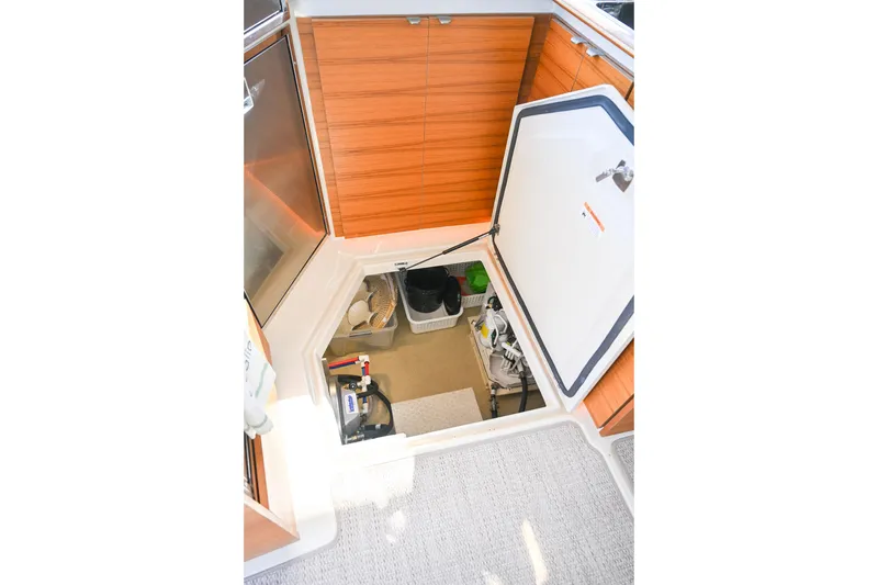 Slide: The Image of 2022 Ranger Tugs R-43 CB interior storage compartment with open hatch and organized equipment. - 58