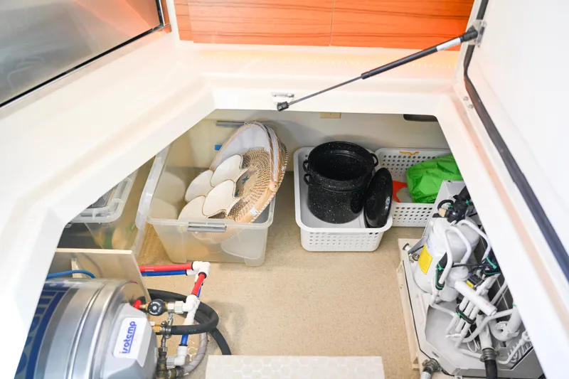 Slide: The Image of Storage compartment in 2022 Ranger Tugs R-43 CB with organized bins and equipment. - 59