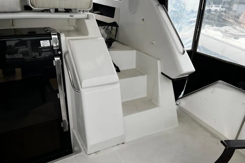 Slide: The Image of Staircase inside 1991 Carver 33 Aft Cabin Motor Yacht, featuring sleek white design. - 10