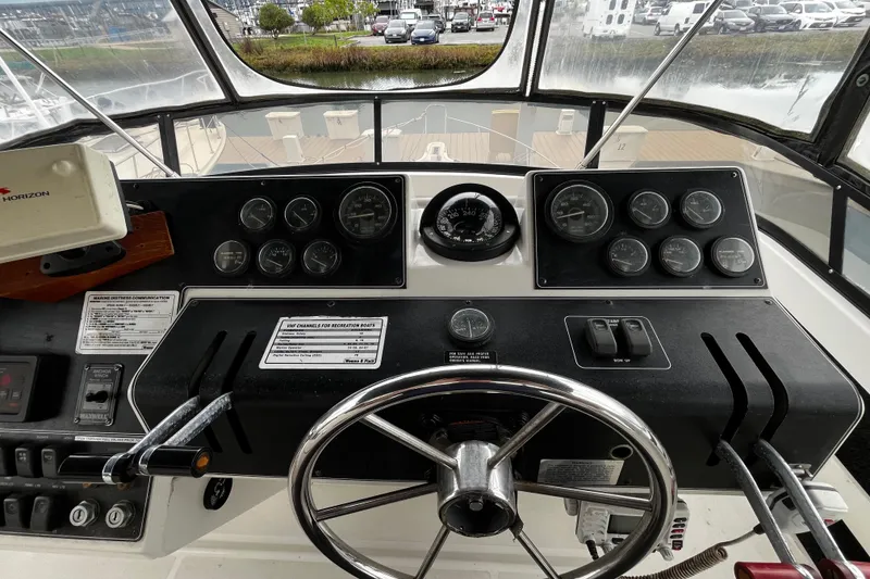 Slide: The Image of 1991 Carver 33 Aft Cabin Motor Yacht helm with gauges and steering wheel. - 11
