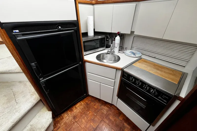 Slide: The Image of Compact kitchen in 1991 Carver 33 Aft Cabin Motor Yacht with appliances and wood accents. - 20
