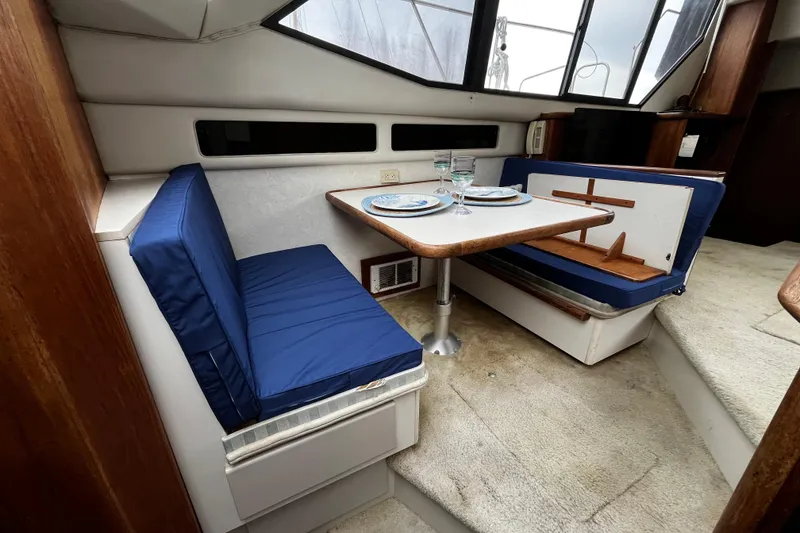 Slide: The Image of Interior of 1991 Carver 33 Aft Cabin Motor Yacht with dining area and blue cushions. - 21