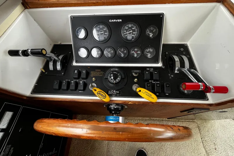 Slide: The Image of 1991 Carver 33 Aft Cabin Motor Yacht control panel with gauges and steering wheel. - 25