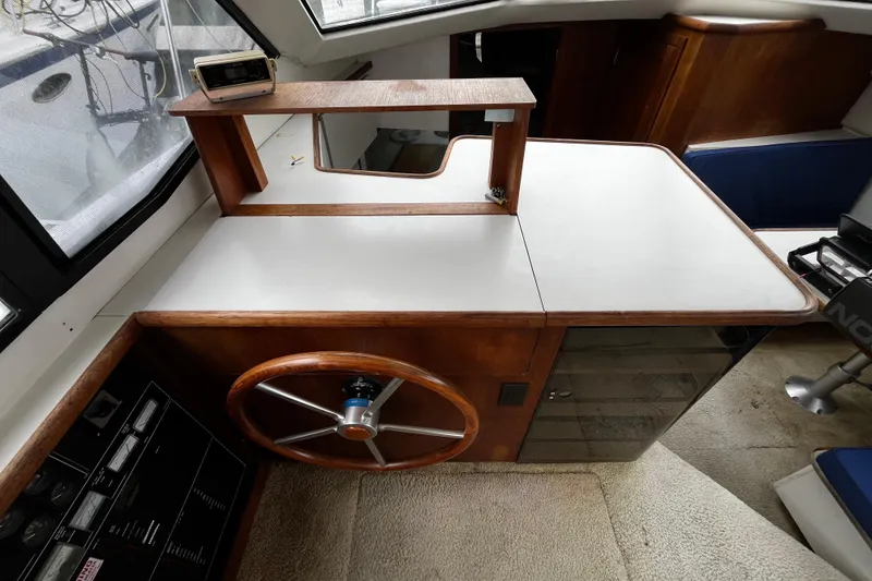 Slide: The Image of 1991 Carver 33 Aft Cabin Motor Yacht helm with wooden steering wheel and navigation equipment. - 29