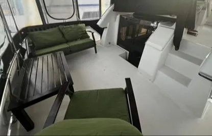 Slide: The Image of 1991 Carver 33 Aft Cabin Motor Yacht interior with green seating and wooden table. - 8